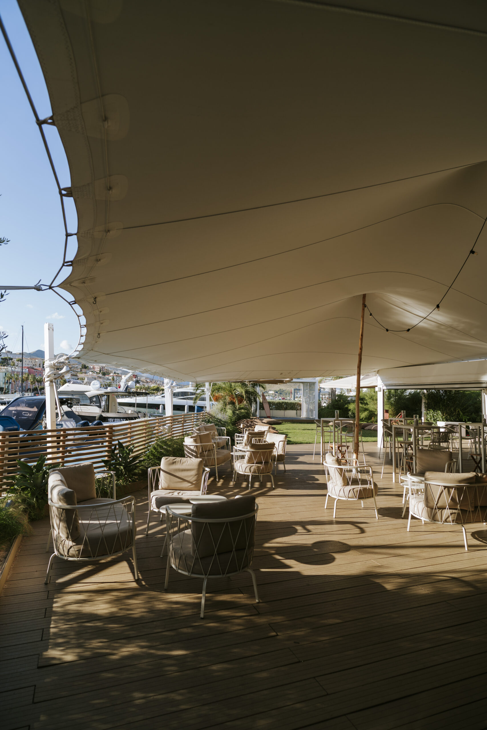 Area coperta della lounge YCG con tavolini e sedute, café e cocktail bar nel porto di Gaeta